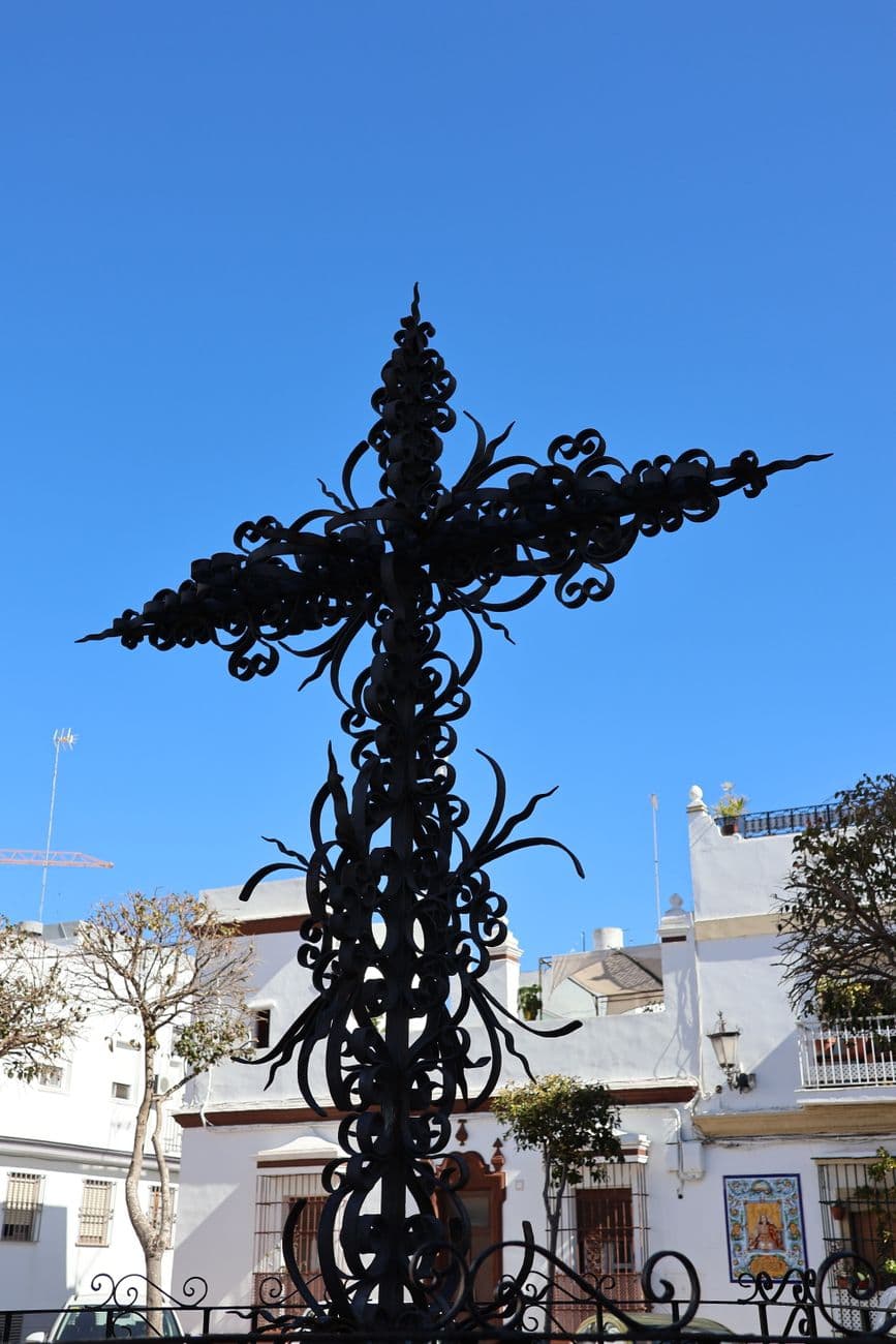 A decorative iron cross with intricate details in San Fernando, Spain.