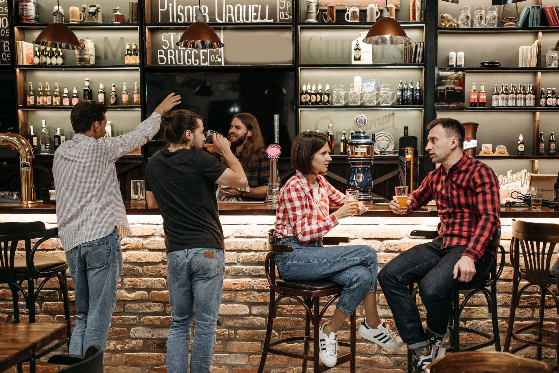 A group of friends socializing and enjoying drinks at a lively bar.