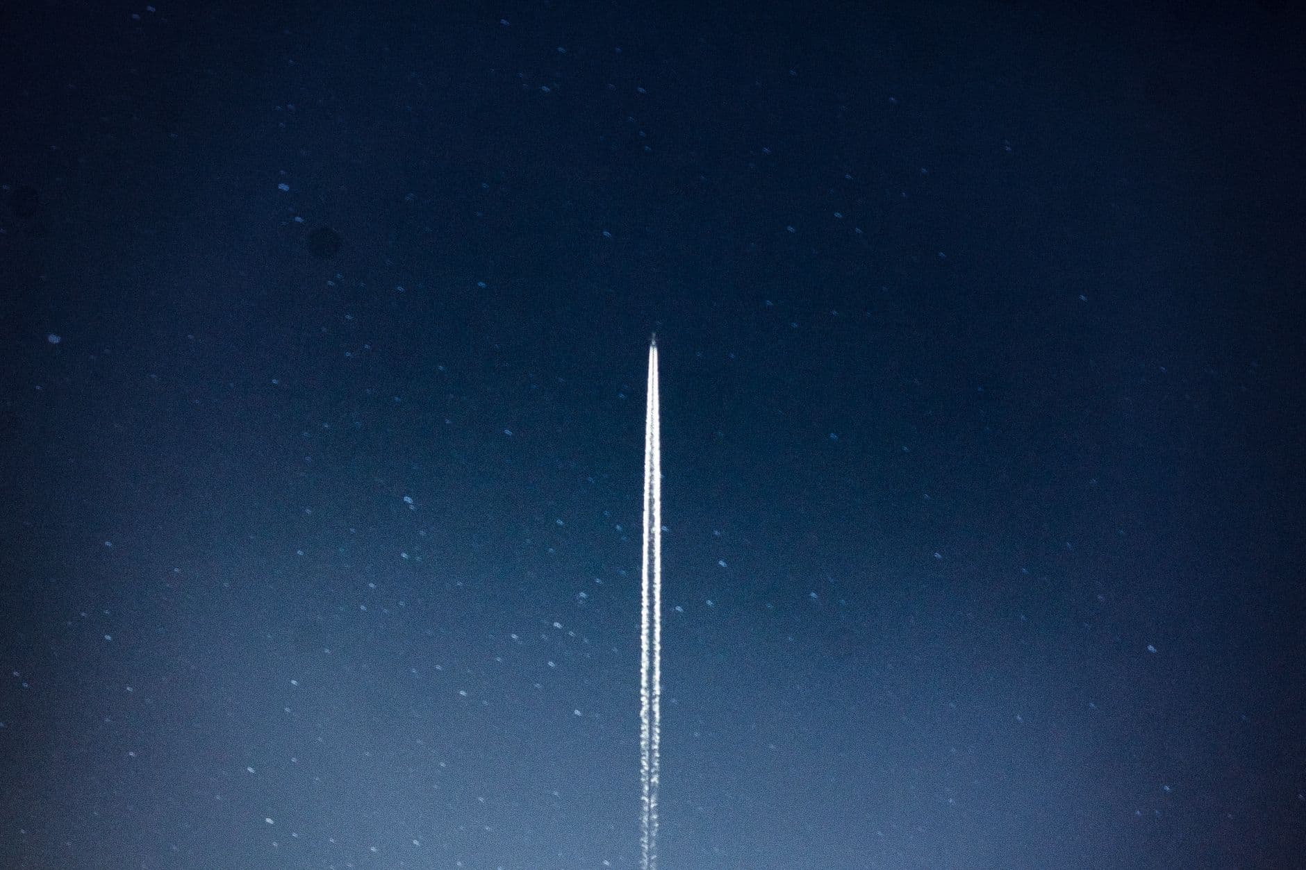 A rocket streaks through a starry night, leaving a trail in outer space.