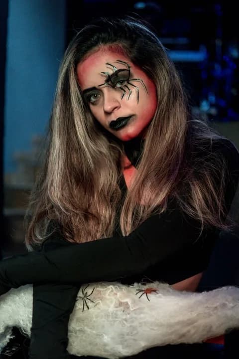 A woman dressed as a spider lady with gothic makeup for Halloween. PNG