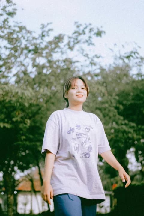 Casual carefree young woman walking outdoors in a park during summer. PNG