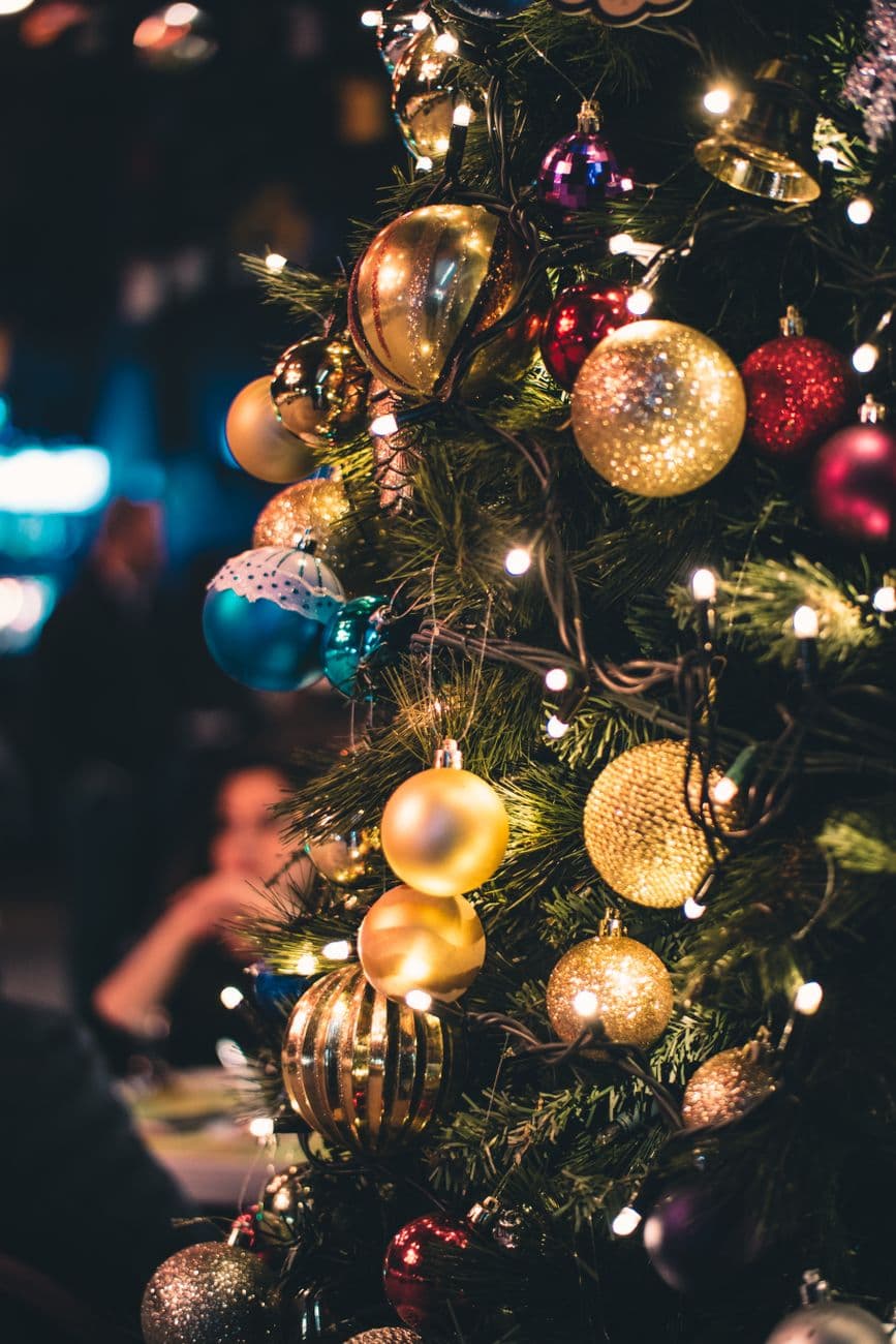 Close-up of a Christmas tree adorned with vibrant ornaments and lights.