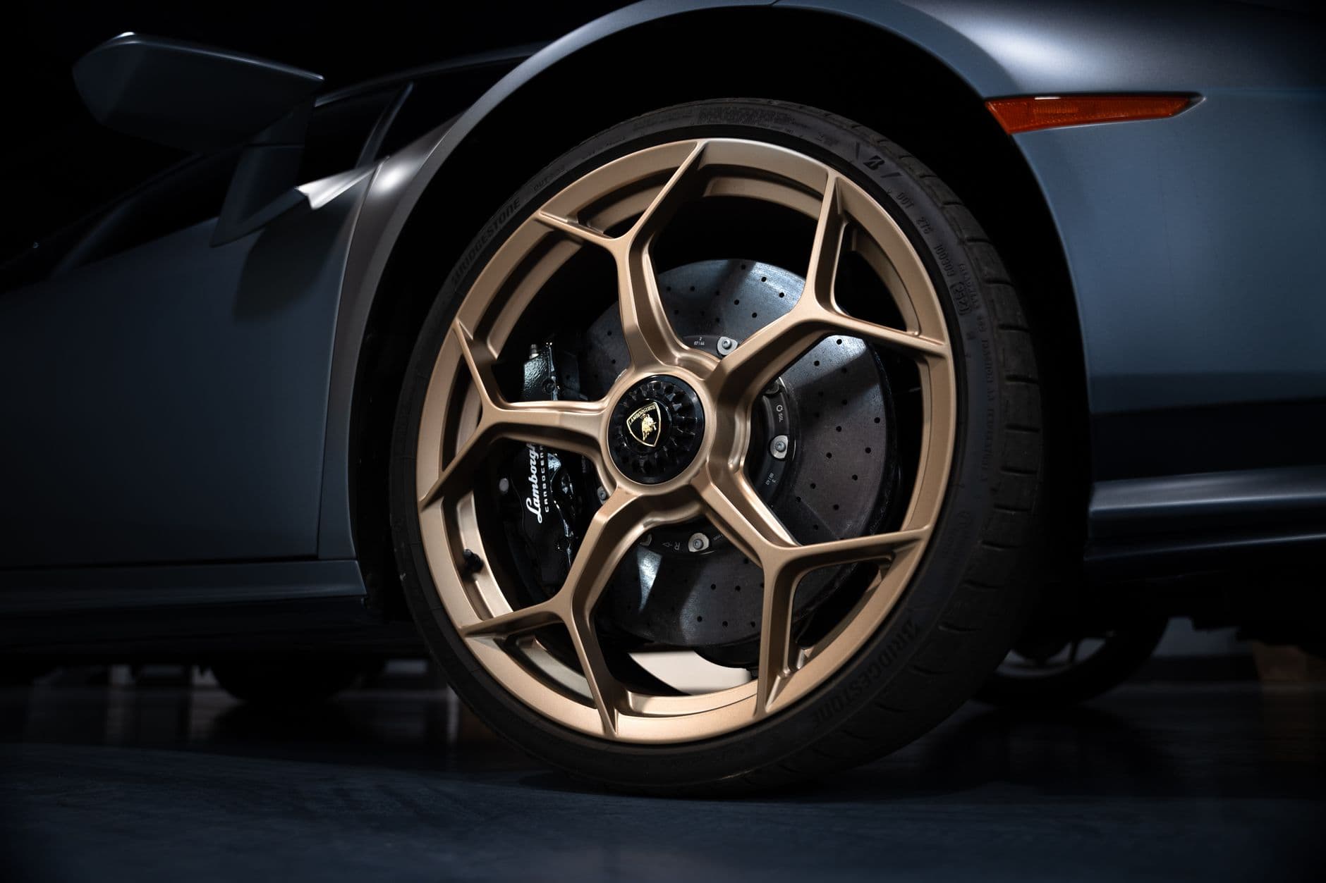 Close-up of a luxury car wheel with golden rims, showcasing sporty elegance.