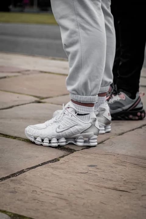 Close-up of trendy sneakers worn outdoors, showcasing street fashion. PNG