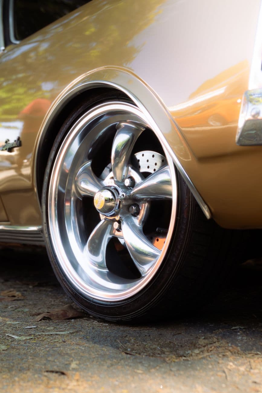 Detailed shot of a classic car's polished chrome wheel with sleek design.