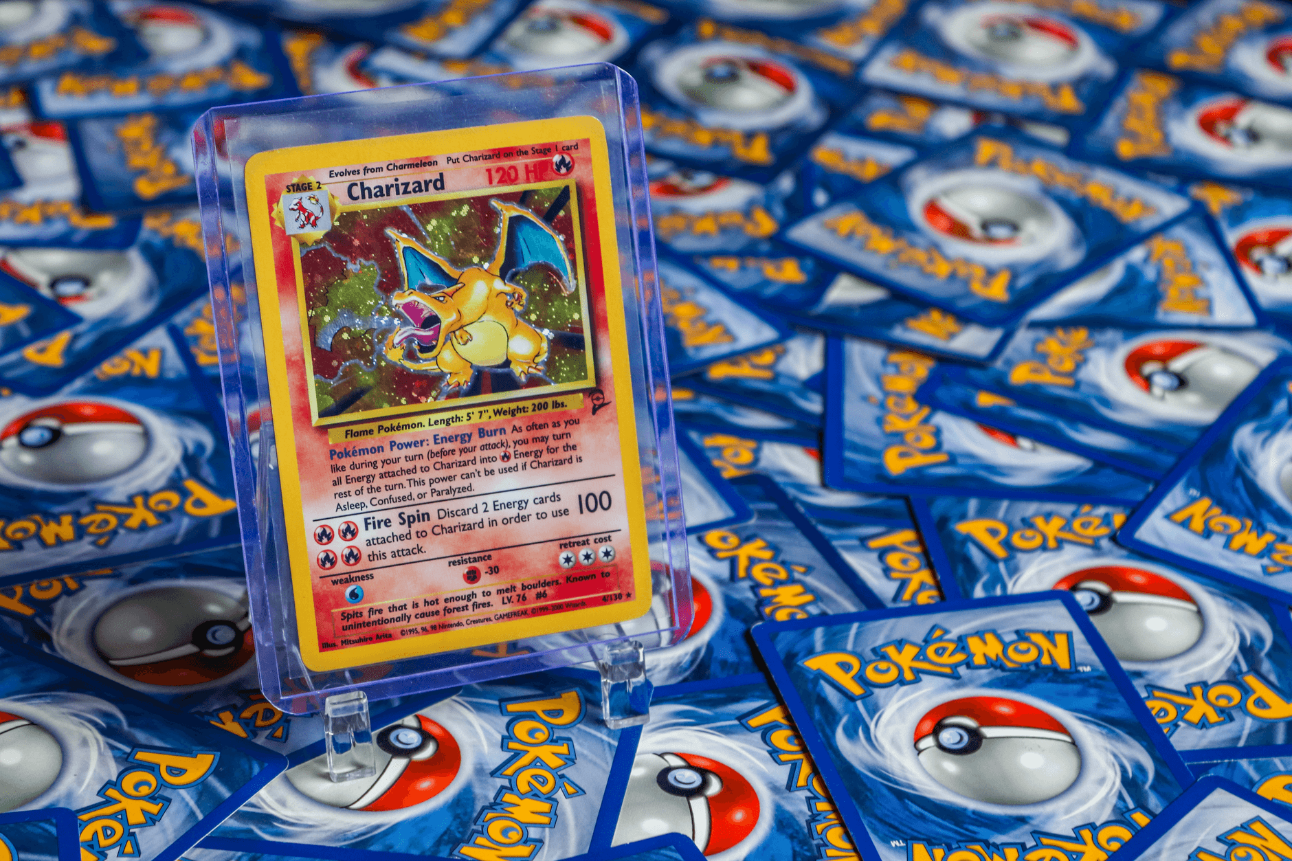 High-value Charizard Pokémon trading card surrounded by various other cards.