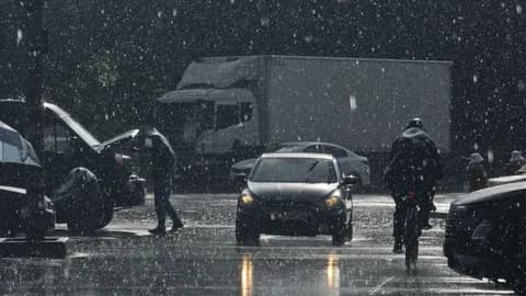 Moody urban street scene in heavy rain with cars and pedestrians. PNG