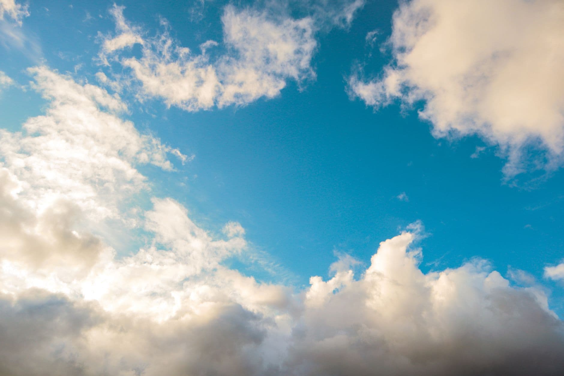 A bright blue sky adorned with fluffy white clouds, creating a peaceful and serene atmosph