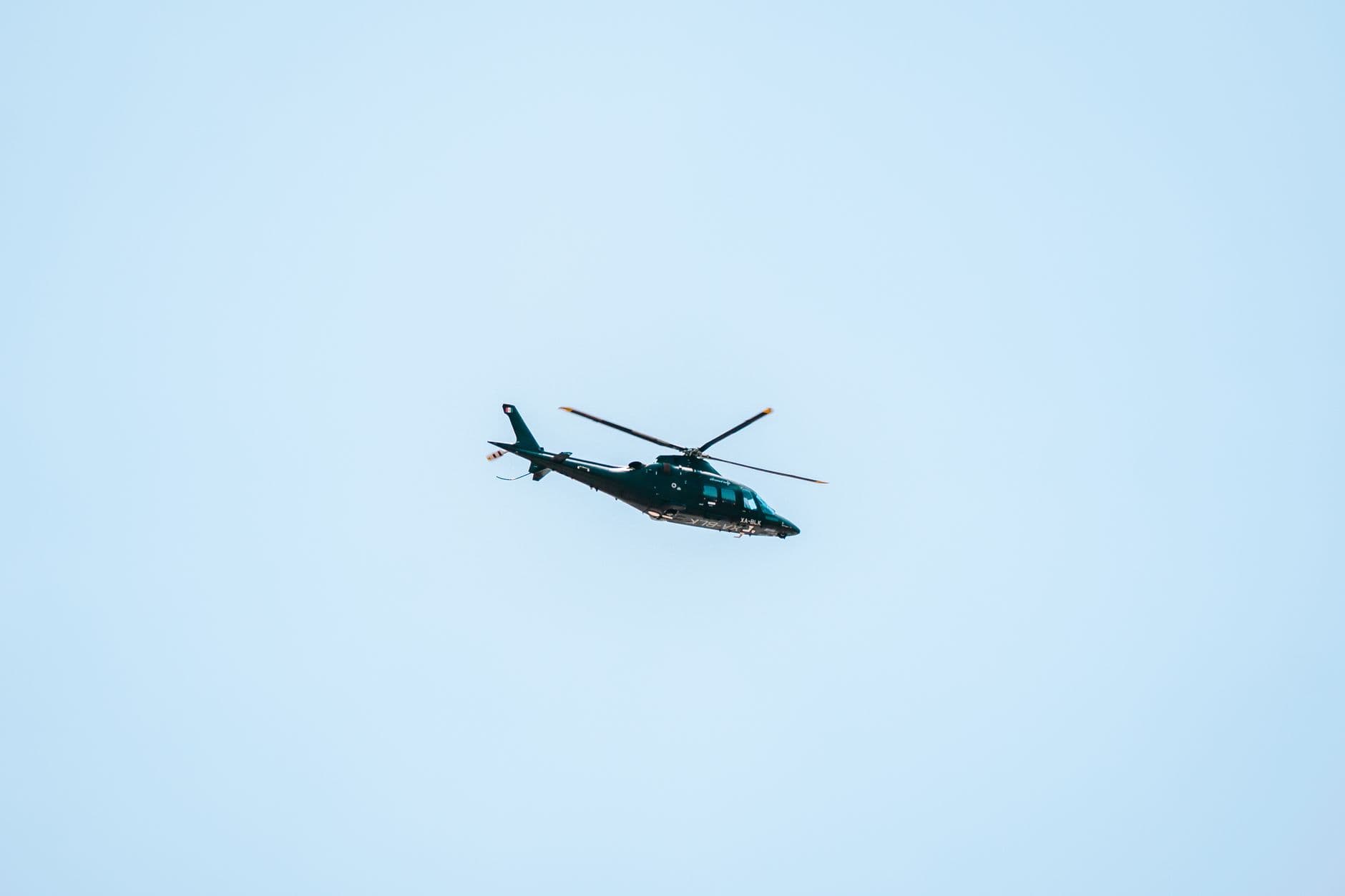 A helicopter flying against a clear blue sky in Ciudad de México, offering a dynamic view