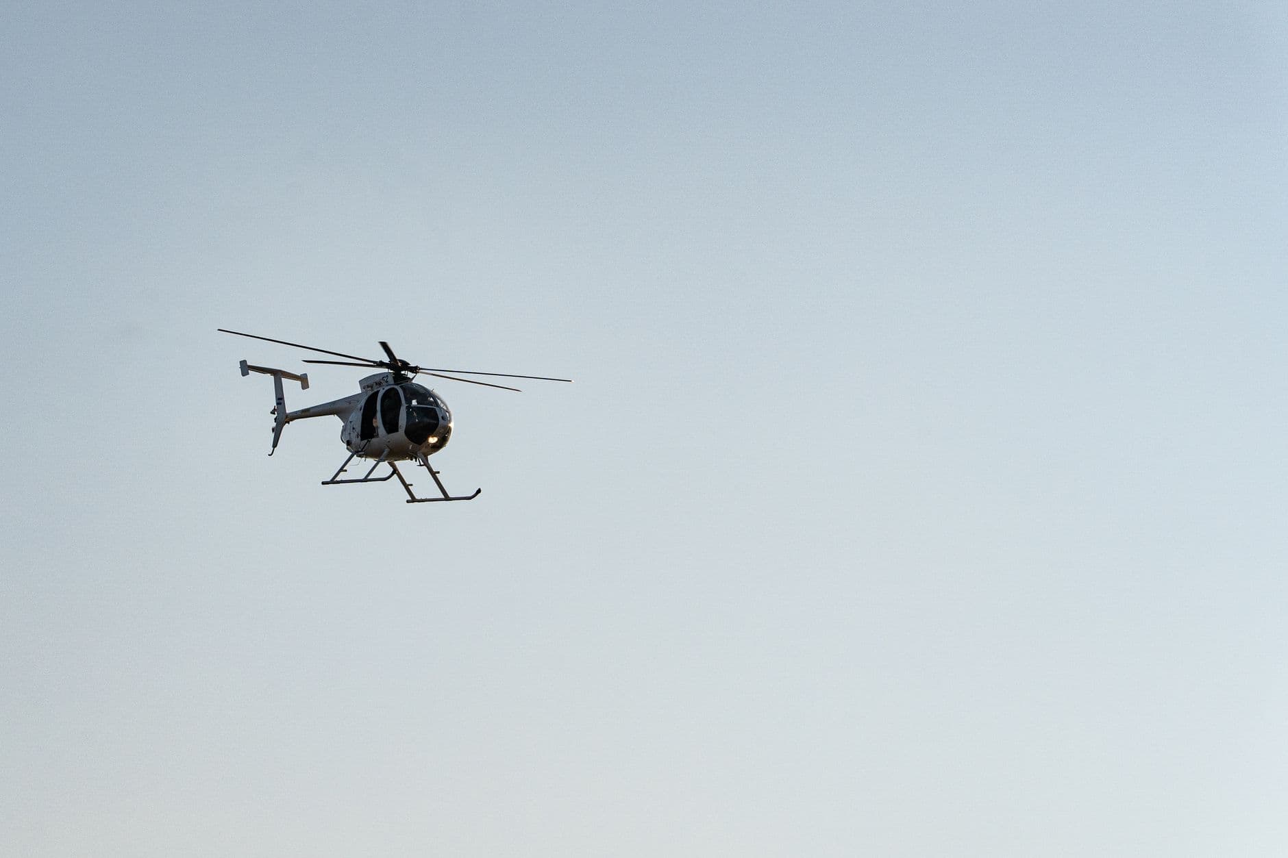 A helicopter flying in the clear blue sky above El Salvador, showcasing aviation in a sere