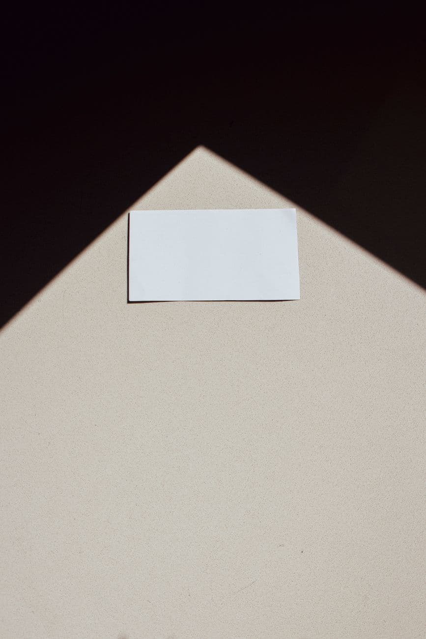 A minimalist photo of a blank business card with a geometric shadow, ideal for design conc