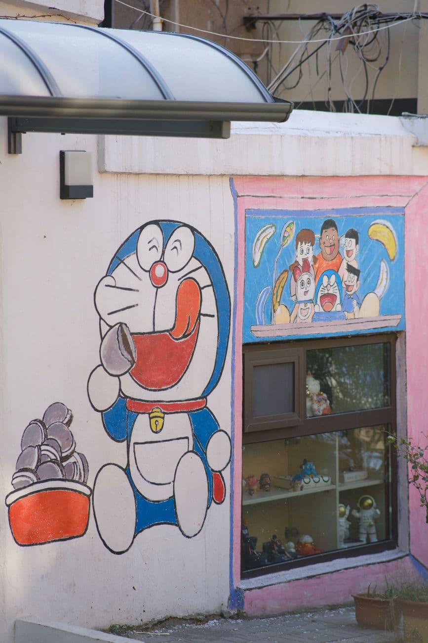 A vibrant cartoon-themed mural decorates an urban wall, featuring popular characters.