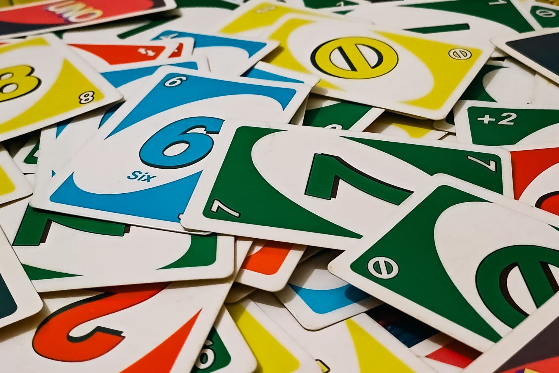 A vibrant display of Uno cards scattered in a random pile, showcasing various numbers and