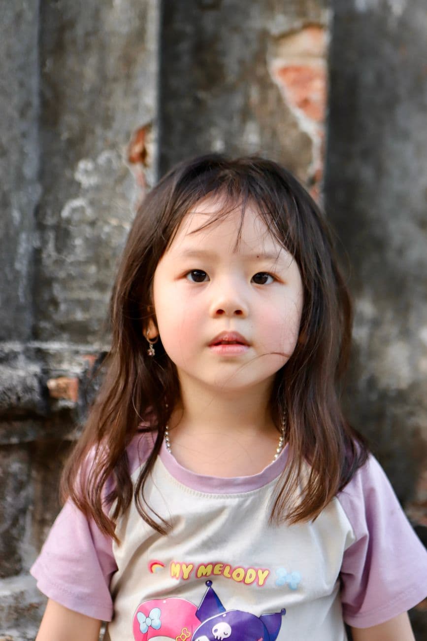 Adorable Vietnamese child captured in an outdoor setting, showcasing innocence and charm.