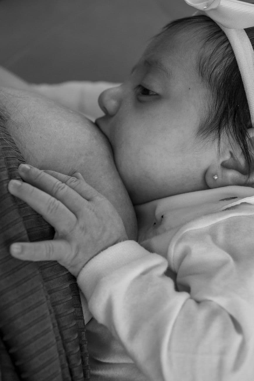 Black and white portrait of a mother breastfeeding her newborn child, showcasing love and