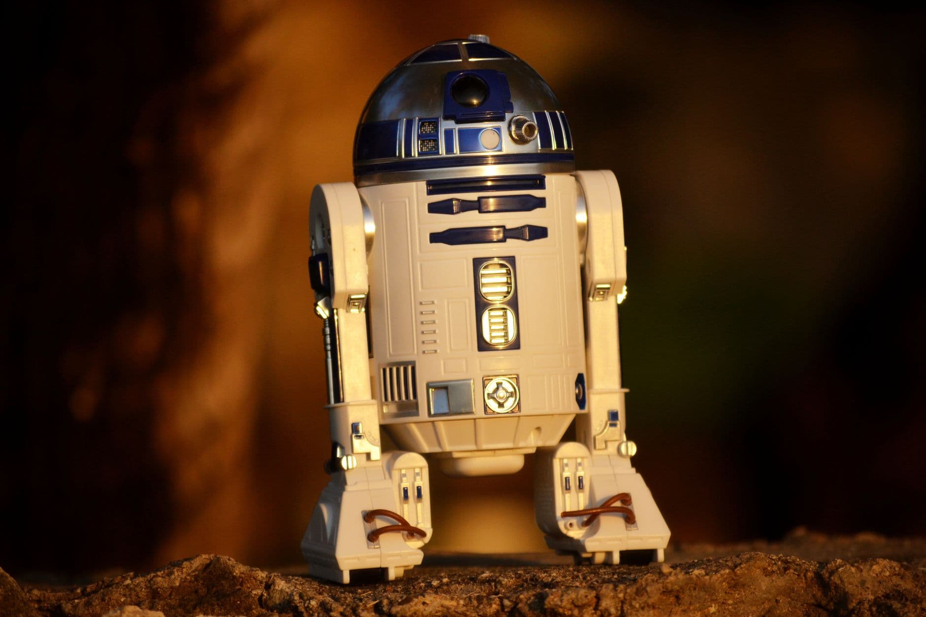 Close-up of a futuristic robot toy outdoors, showcasing its metallic and plastic component