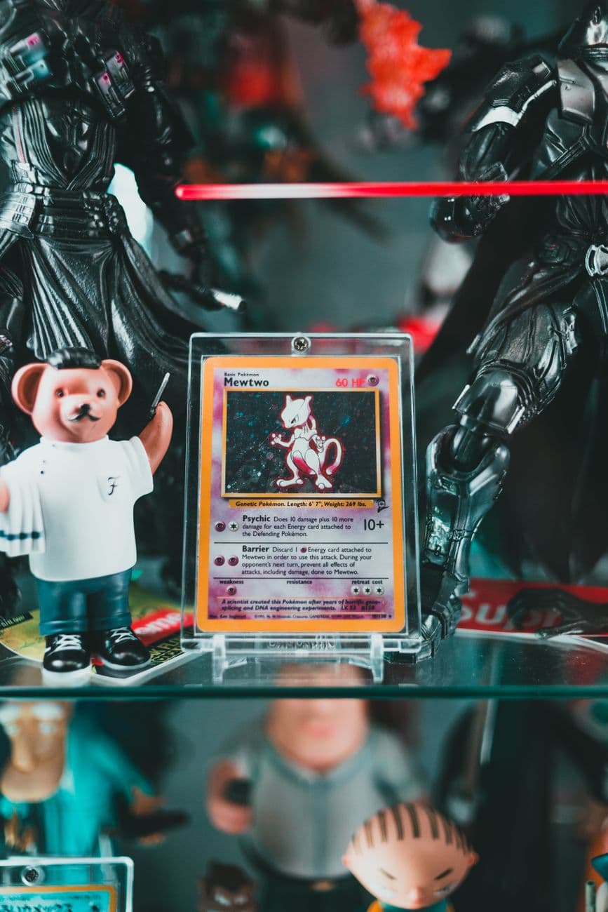 Close-up of rare Mewtwo Pokemon card displayed with various toy figures. Perfect for colle