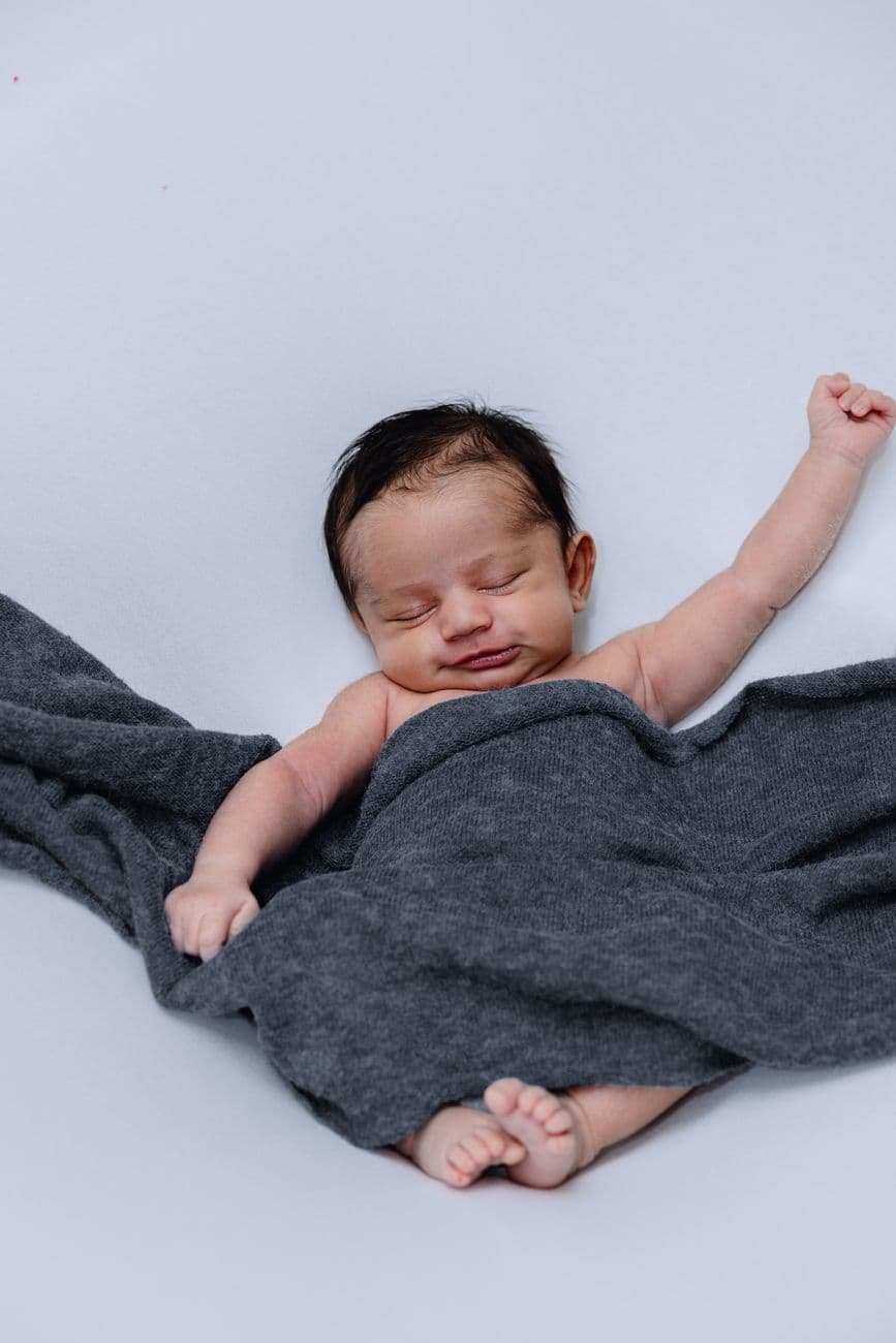Cute baby peacefully sleeping wrapped in a soft, cozy blanket, capturing a serene moment.