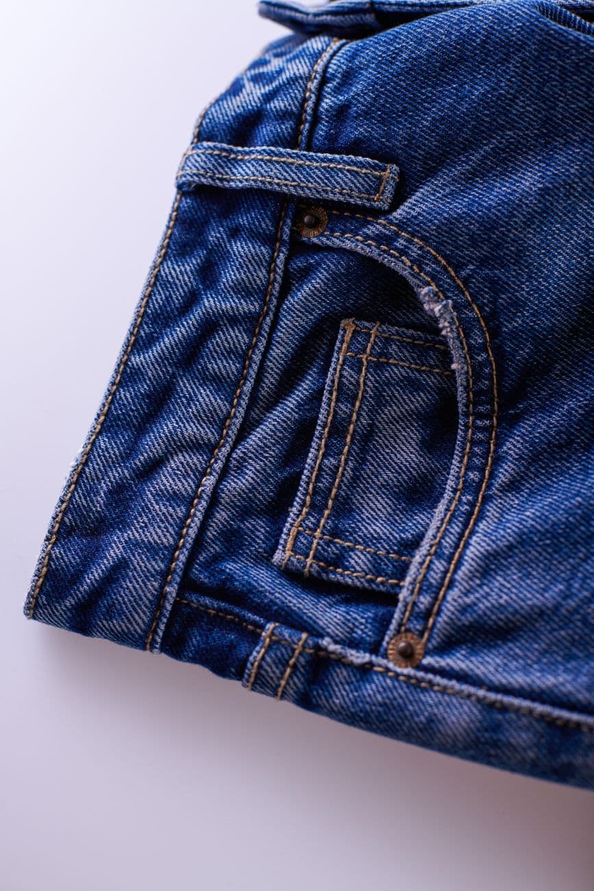 Detailed close-up of classic blue denim jeans, showcasing the material and stitching.