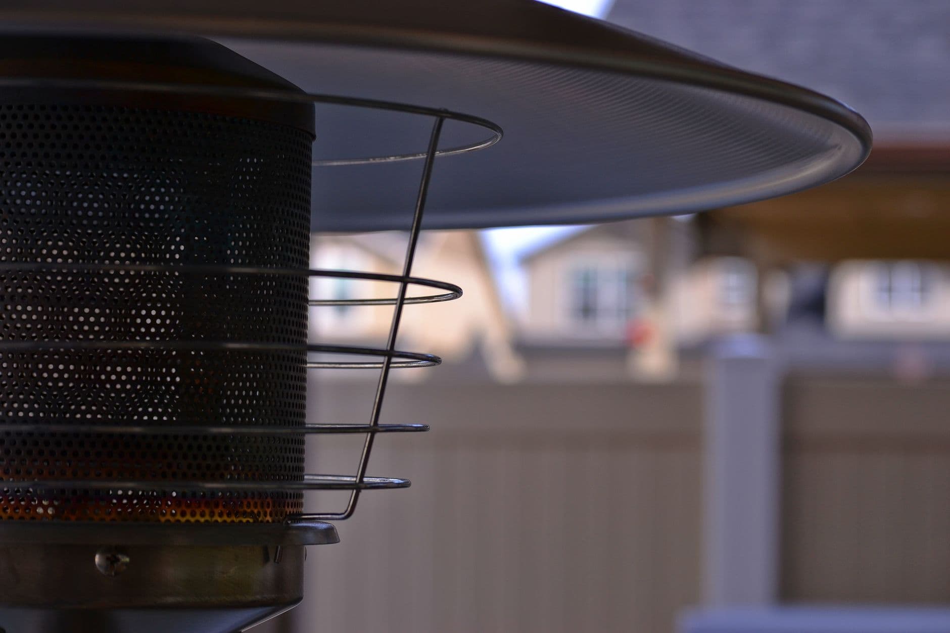 Detailed view of a modern outdoor patio heater with blurred suburban background, perfect f