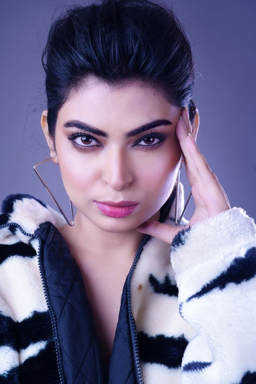 Elegant close-up portrait of a young woman with fashionable makeup and attire, exuding con