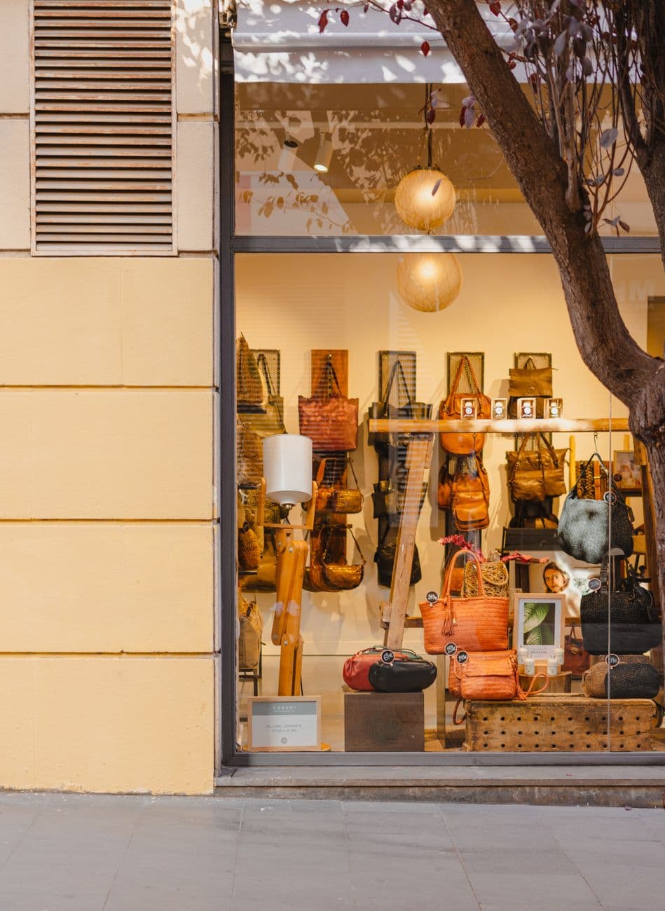 Elegant handbag store display in Barcelona, featuring a variety of stylish bags through a