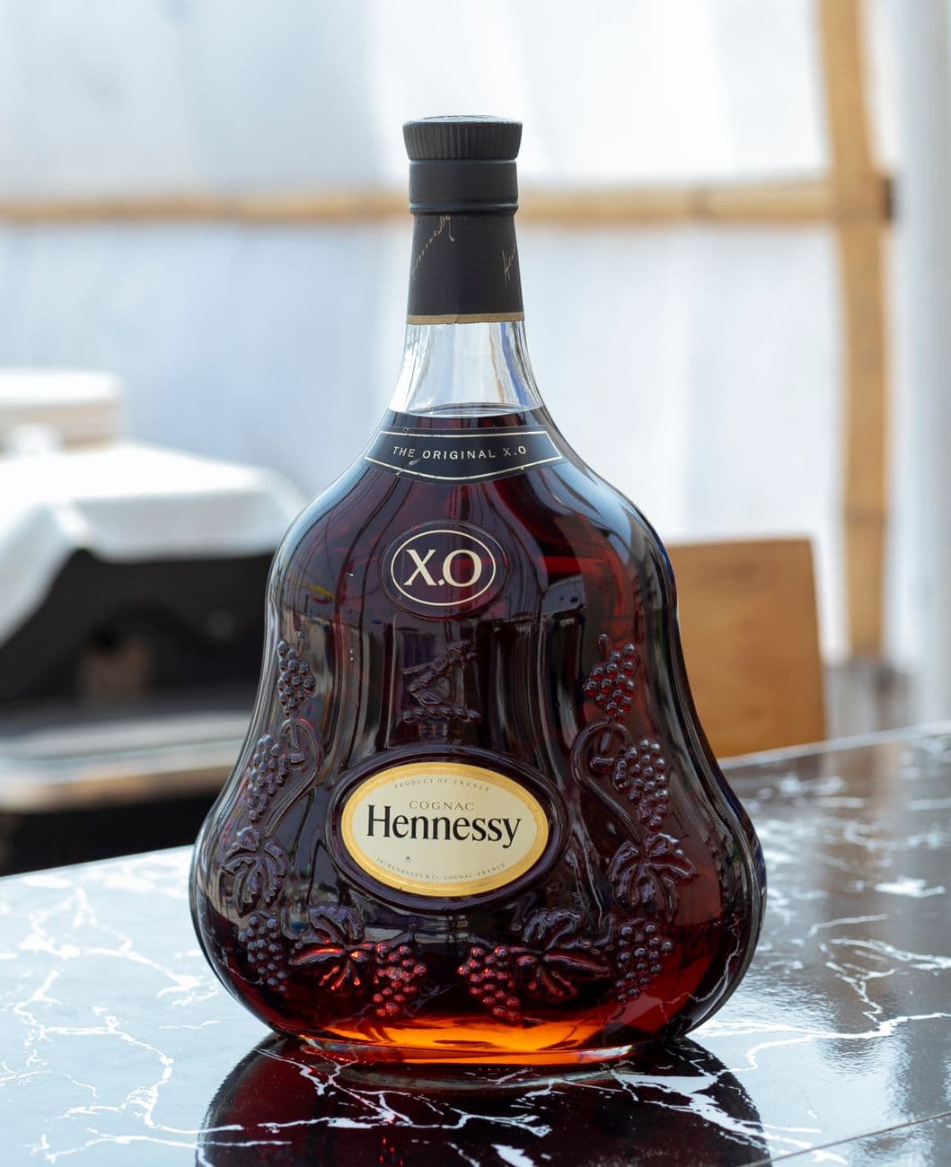 Elegant Hennessy XO cognac bottle on a marble table, perfect for luxury branding and adver
