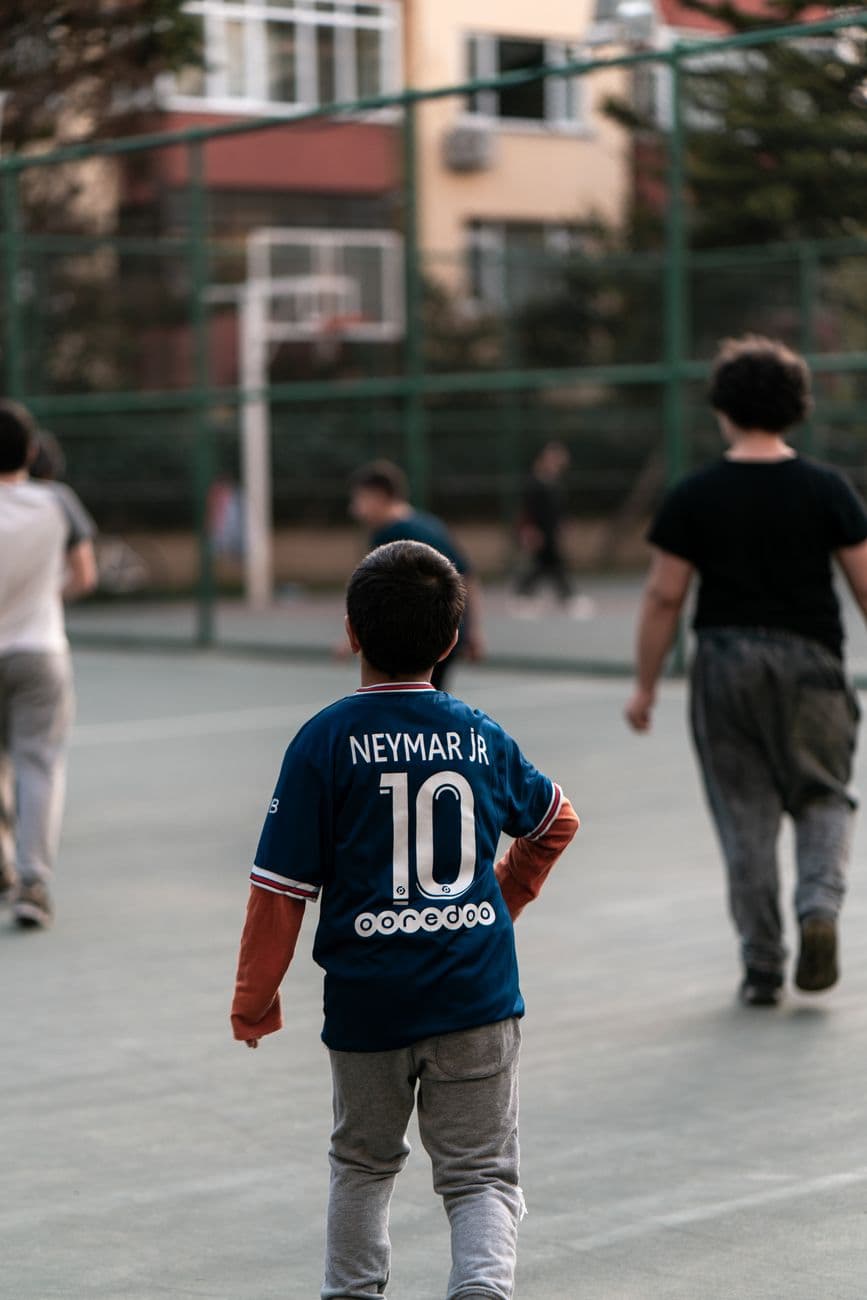 Kids in jerseys playing basketball on an outdoor court in Istanbul, creating a joyful and
