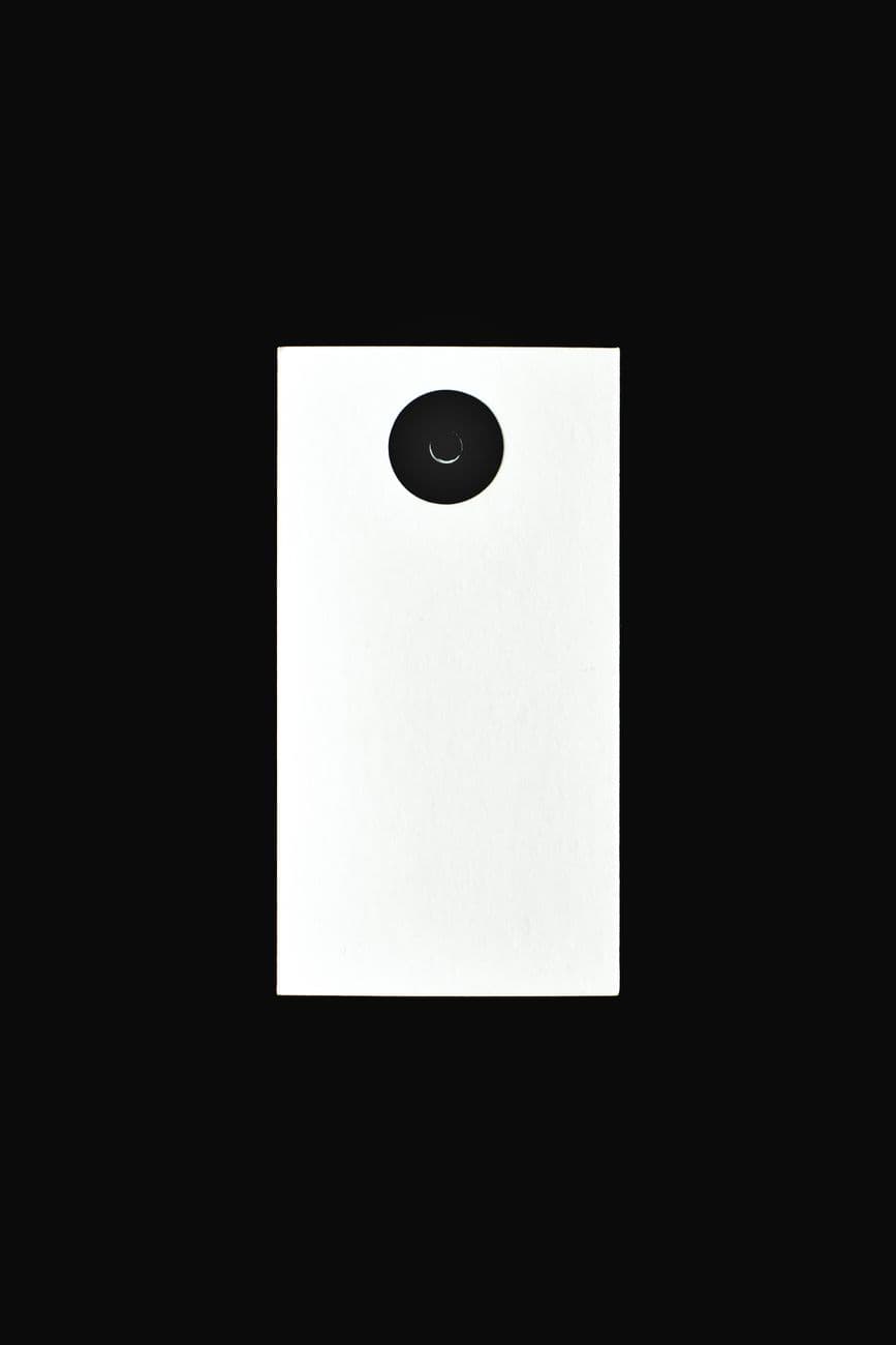 Minimalist black and white design featuring a vertical view of a camera lens isolated on a