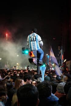 People celebrating in Buenos Aires, Argentina at night, featuring a person in a sports jer PNG