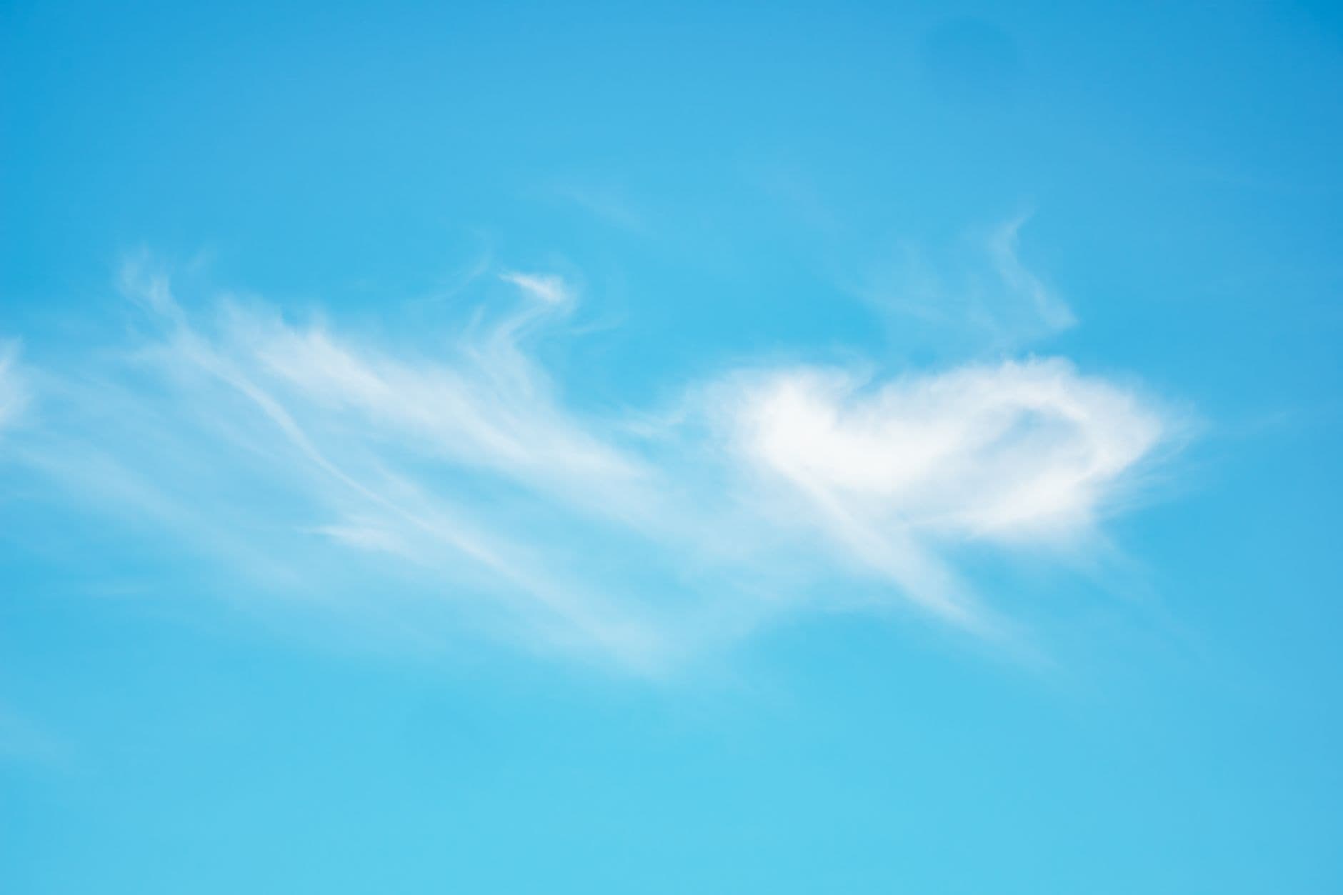Serene view of wispy white clouds set against a vibrant blue sky, ideal for backgrounds.