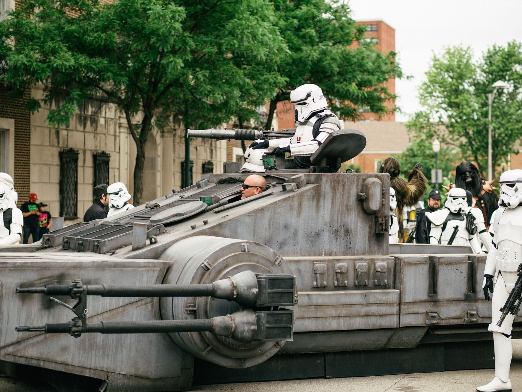 Stormtroopers participating in a cosplay parade featuring a tank-like vehicle in Joliet, I