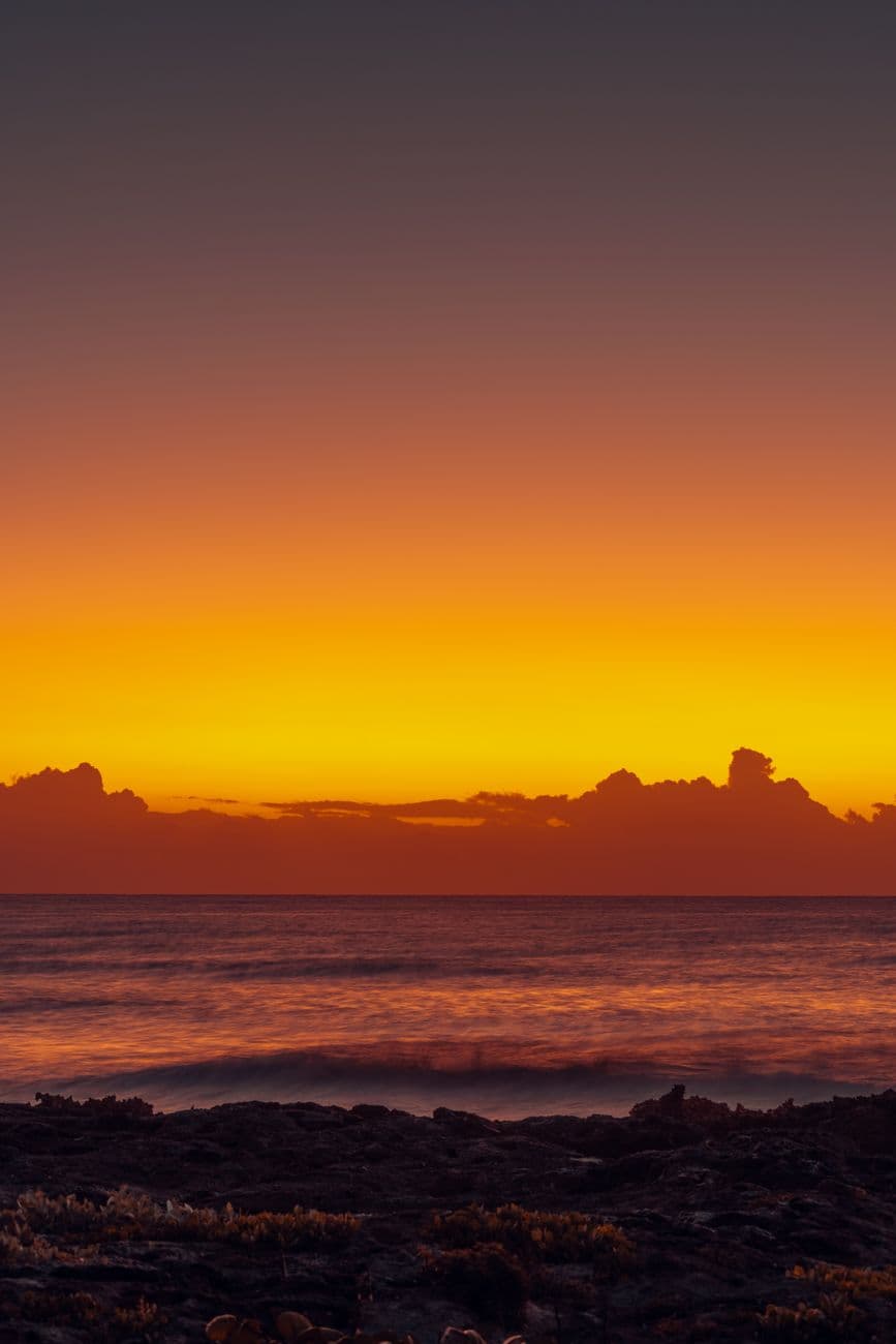 Stunning golden sunrise over Akumal Beach, Quintana Roo. Vibrant orange sky reflecting on