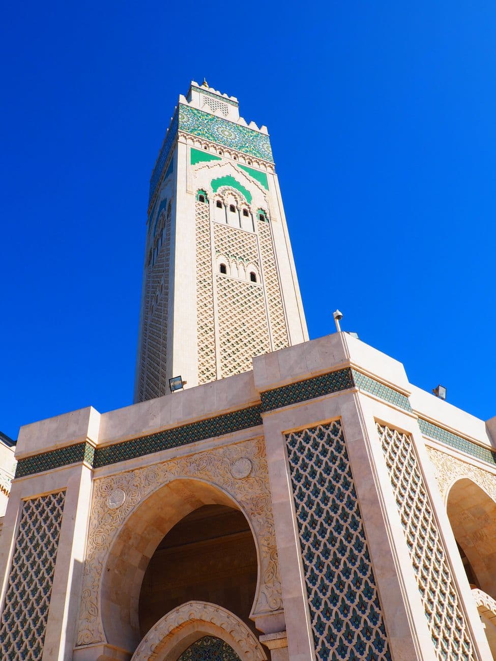 Stunning view of the Hassan II Mosque minaret against a clear blue sky in Casablanca, Moro