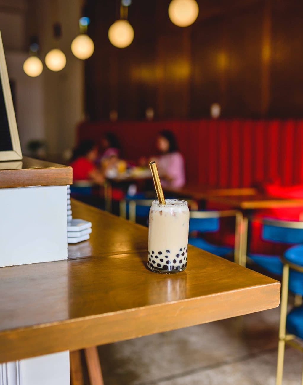 Stylish bubble tea with tapioca pearls on wooden table in a cozy cafe setting. Perfect amb