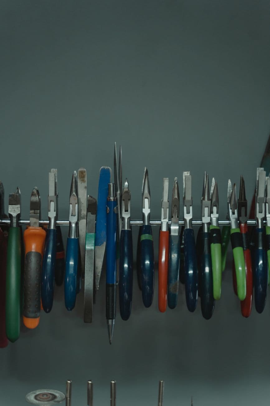Variety of tools neatly organized on a wall rack, ideal for workshop environments.