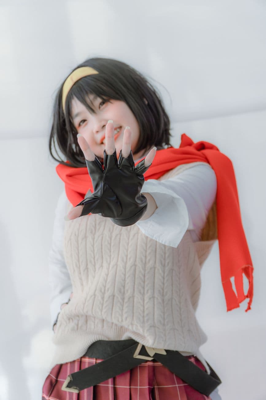 Vibrant portrait of a woman in cosplay with gloves and colorful attire, striking a playful